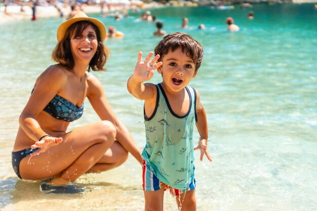 Portrait of Mother and son enjoying the summer on the beach in summer of Paralia Mikros Gialos in the south of the island of Lefkada Greece