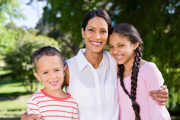 Portrait of mother standing with her kids in park