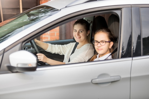 Portrait of mother and two daughters riding in car