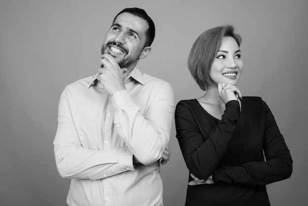 Portrait of multi ethnic couple together and in love on gray in black and white