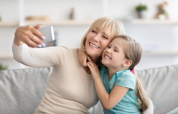 Portrait of multi-generation family taking selfie together at home