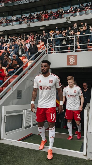 Portrait of a Multiethnic Footballer in White and Red Uniform Walking Out of the Tunnel onto the Sp