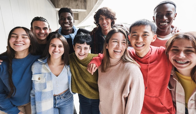 Portrait of multiracial friends having fun smiling on camera outdoor - Focus on asian guy face