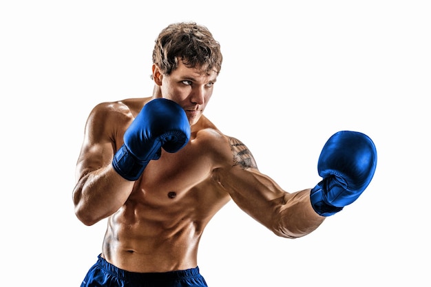 Portrait of muscular boxer who training and practicing uppercut in blue gloves on white background