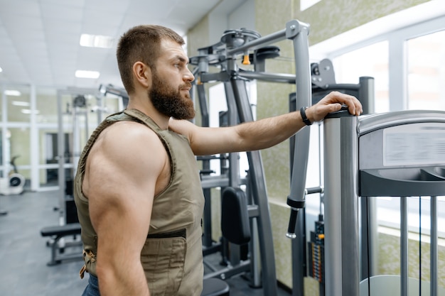 Portrait muscular caucasian bearded adult man in gym