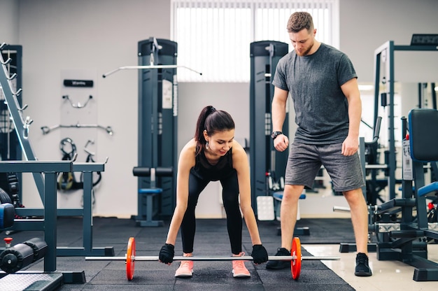 Portrait of muscular young people with beautiful athletic bodies in a gym Fitness bodybuilding and health care concept