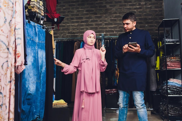 Portrait of a muslim businesswoman checks availability of goods by using the touch pad while