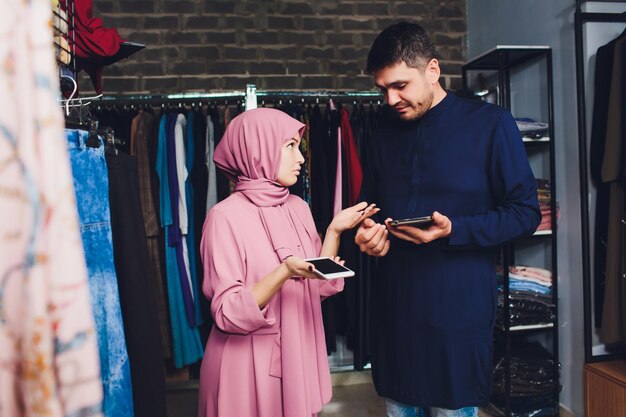 Portrait of a muslim businesswoman checks availability of goods by using the touch pad while