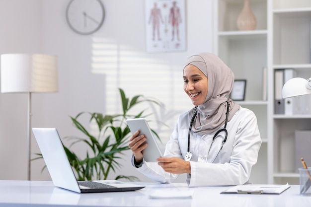 Portrait muslim female doctor in hijab woman doctor with tablet computer using application smiling