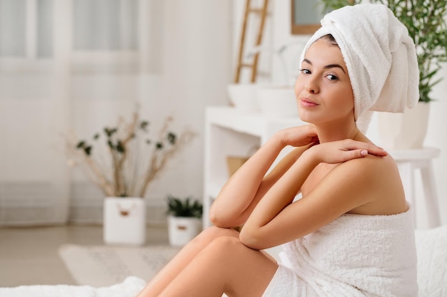 Portrait of naked woman sitting on bed at home