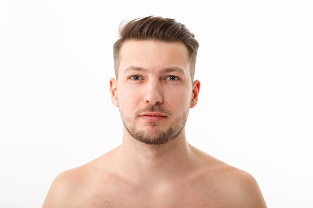 Portrait of a naked young man with stubble on a white background