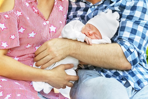 Portrait of newborn baby in arms of parents concept of children's day