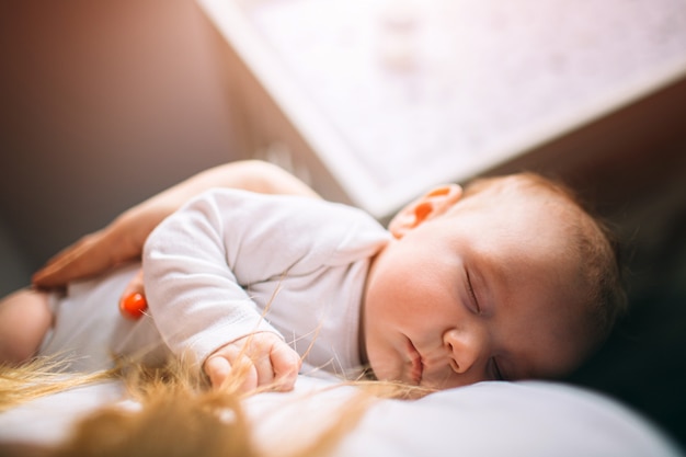 Portrait of a newborn baby. Mother holds a child in her arms. The first year of life. Care and health.