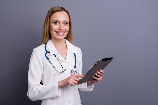 portrait of nice attractive cheerful blonde girl doc using the gadget