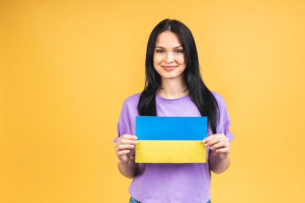 Portrait of nice beautiful lovely glad cheerful woman holding in hands Ukrainian flag having fun