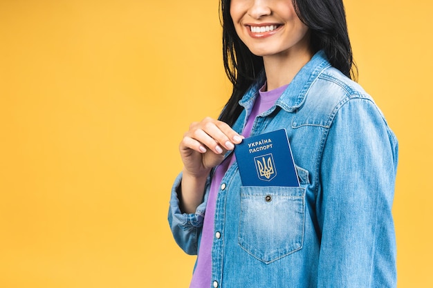 Portrait of nice beautiful lovely glad cheerful woman holding in hands ukrainian passport having fun isolated over yellow pastel color background