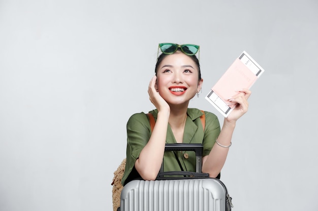 Portrait of nice smiling woman holding passport and flying tickets