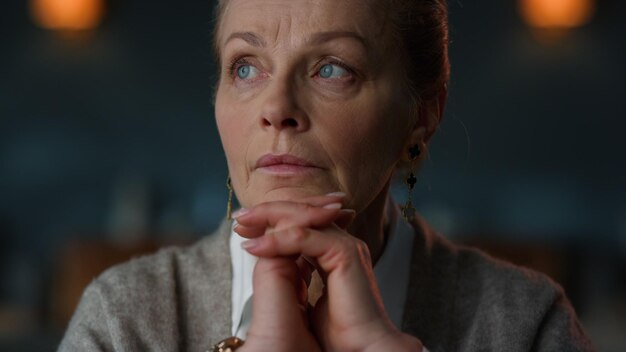 Portrait old business woman thinking at home interior Closeup thoughtful senior businesswoman posing indoors Close up pensive elderly woman face keeping chin on palms inside