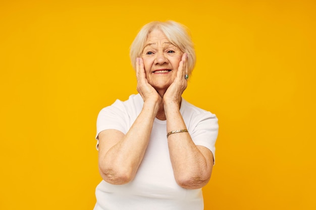 Portrait of an old friendly woman in white tshirt posing fun isolated background