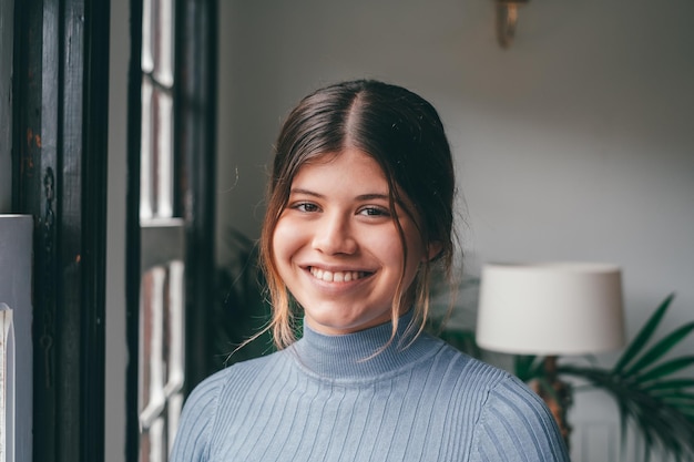 Portrait of one young beautiful and attractive woman smiling and enjoying having fun looking at the camera alone at home Close up of female person relaxing indoorxA