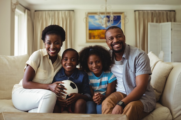 Portrait of parents and kids watching television in living room