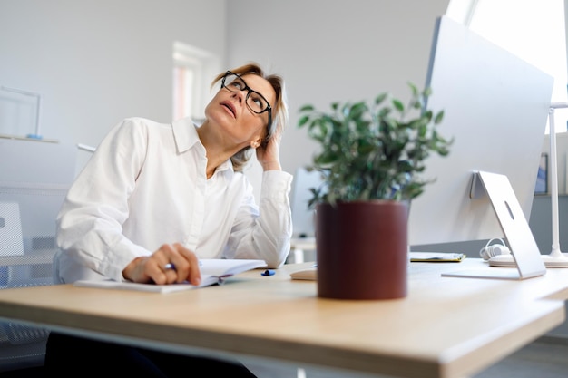 Portrait of a pensive female office worker sitting at her desk