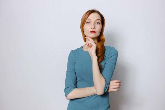 Portrait of a pensive red-haired woman in a blue dress