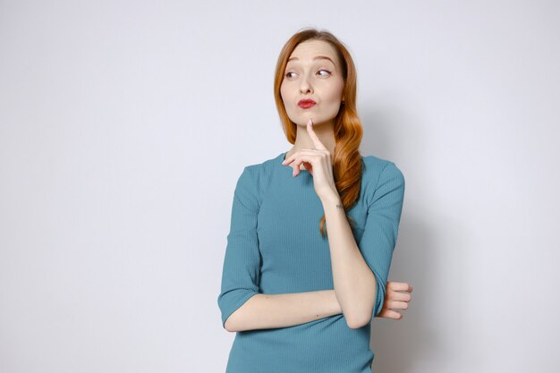 Portrait of a pensive red-haired woman in a blue dress