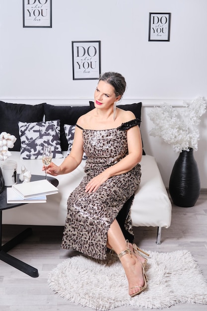 Portrait of pensive senior woman sitting on couch and celebrating birthday at home