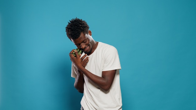 Portrait of person holding pot with plants for botany passion