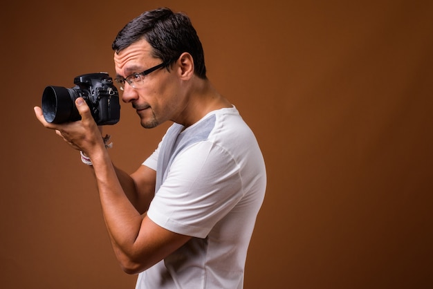 Portrait of photographer man taking picture on brown