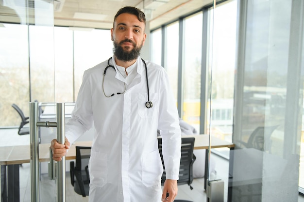 Portrait of pleasant young Arabian doctor in white coat