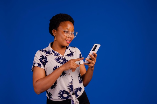 Portrait of pleased blonde woman smiling and using mobile phone