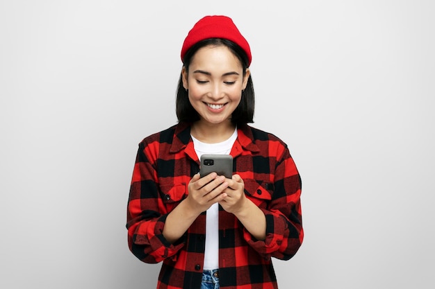 Portrait of positive attractive woman using mobile phone typing message