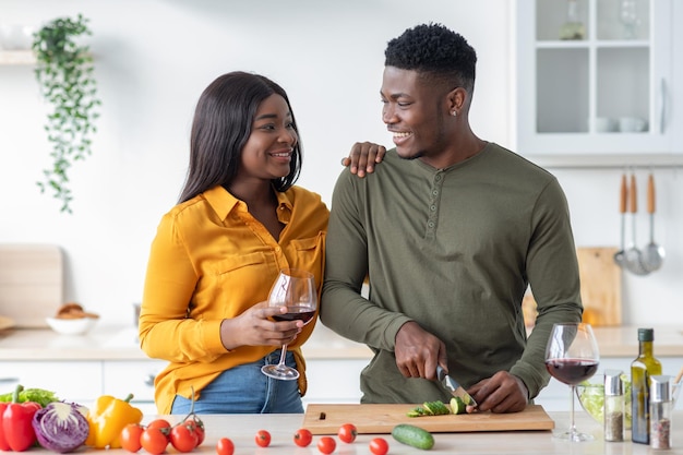 Portrait of positive black married couple relaxing in kitchen together