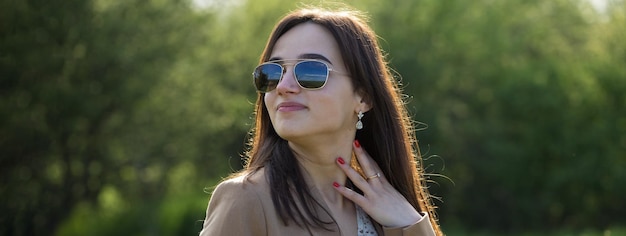 Portrait of a positive cheerful brunette girl in a green spring park