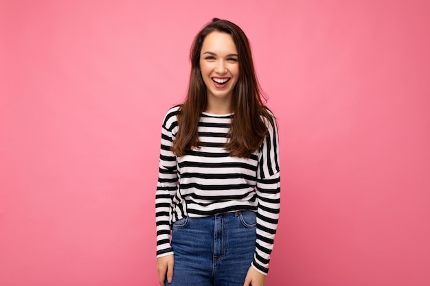 Portrait of positive cheerful fashionable woman in casual clothes isolated on pink background with