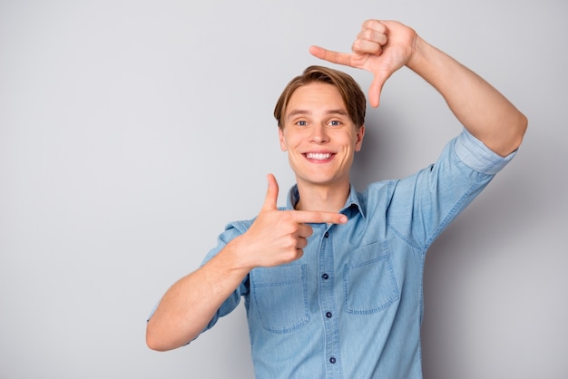 Portrait of positive cheerful guy make photo with his hands index thumb fingers focus wear stylish clothes isolated over grey color background