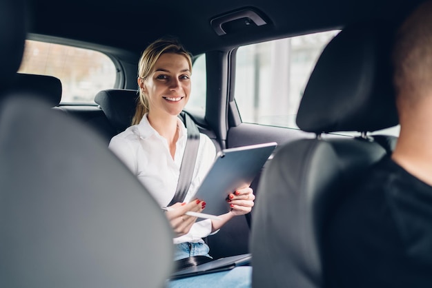 Portrait of positive female economist working with accounting via modern touch pad