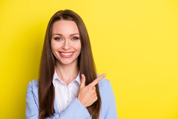 Portrait of positive marketer trader agent lady point index finger copyspace indicate business adverts promotion wear blue suit isolated over bright color background