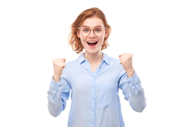 Portrait of positive redhead girl in business shirt emotionally rejoices and feels happy isolated on white background advertising banner