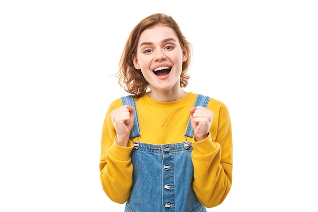 Portrait of positive redhead girl in casual jeans emotionally rejoices and feels happy isolated on white background advertising banner