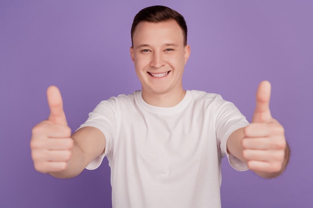 Portrait of positive reliable guy raise thumb up on purple background