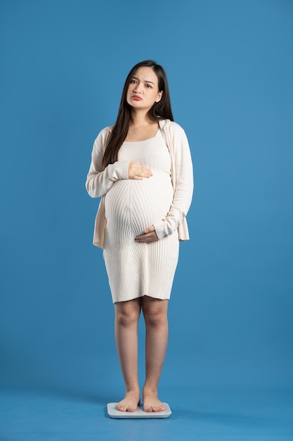 Portrait of pregnant asian woman isolated on blue background