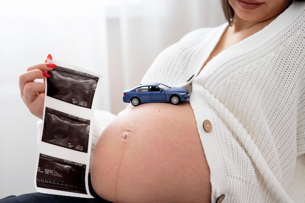 Portrait of a pregnant woman the female holds an ultrasound in her hands waiting for the baby