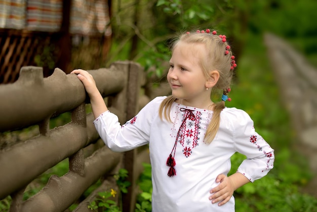 Portrait of a preschool girl with flowers in a Ukrainian embroidered shirt Viburnum in hair