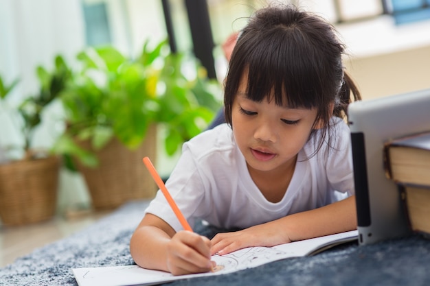 Portrait of preschool kid using tablet for his homework,Soft focus of Child doing homework by using digital tablet searching information on internet,E-learning or Home schooling education concept