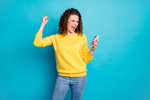 Portrait of pretty amazed girl using device gadget browsing web isolated over blue color background