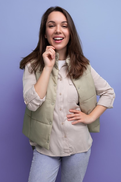 Portrait of pretty brunette young woman in shirt and jeans with hair styling