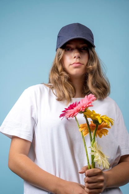 Portrait of a pretty Caucasian girl with gerbera flowers on a blue background